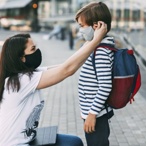 Mother Adjusts Her Sons Mask. A Mother And Child On Their Way To