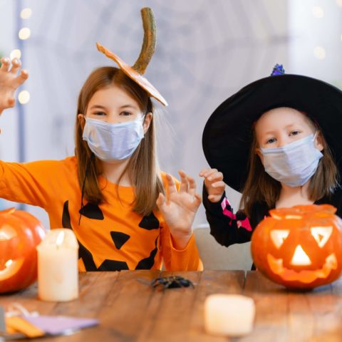 Cute little children girls in carnival costumes wearing face mas