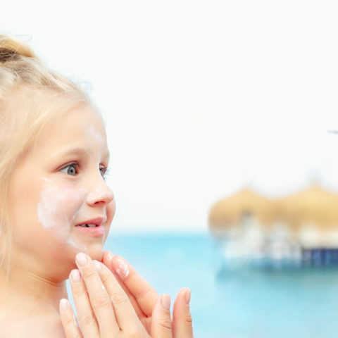 Mother Applying Sunscreen Protection Creme On Cute Little Toddle