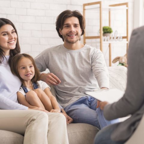 Happy Parents With Little Daughter Sitting Together At Psycholig